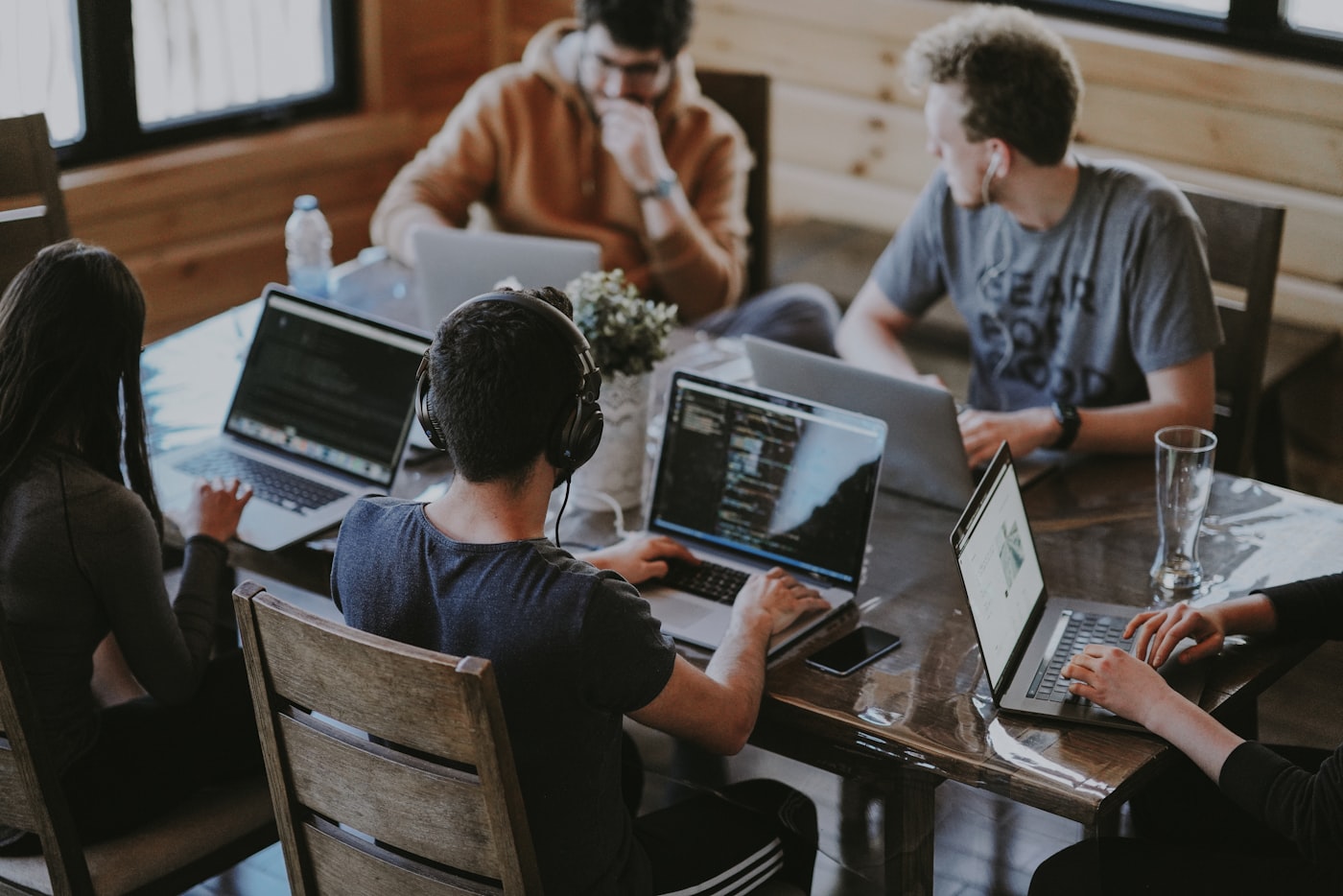 Groupe de personnes travaillant ensemble autour d'une grande table en bois